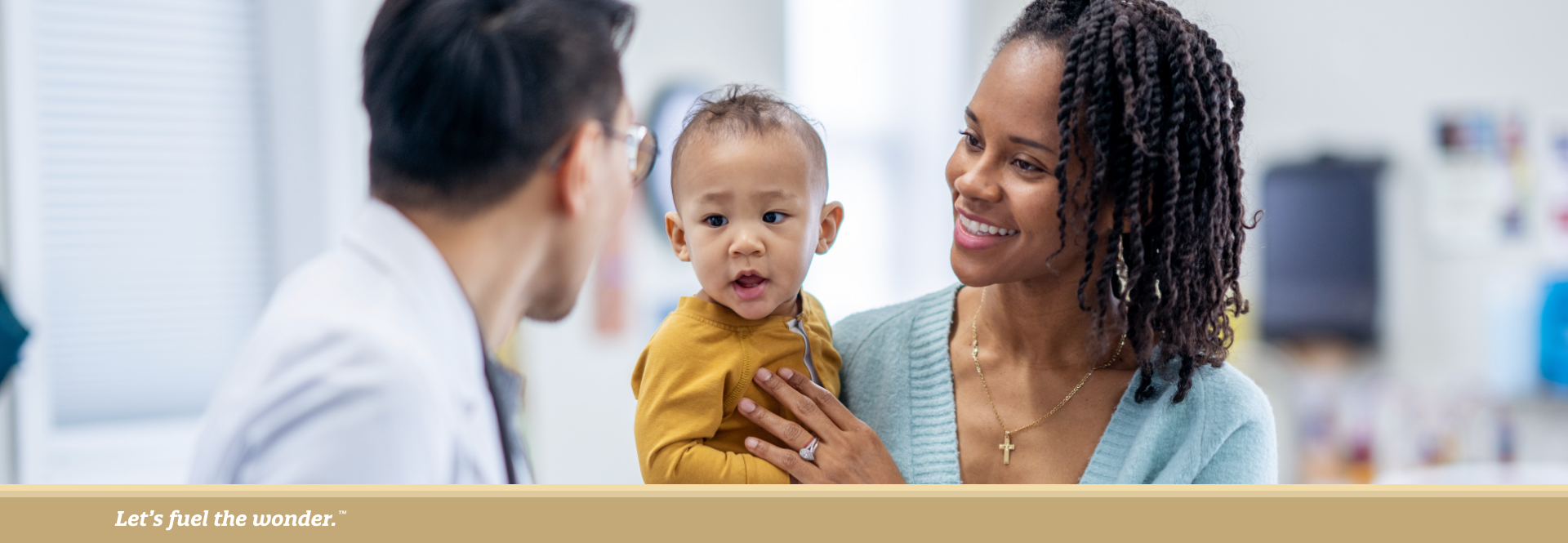 Mother holding her baby while speaking with a pediatrician during a medical consultation