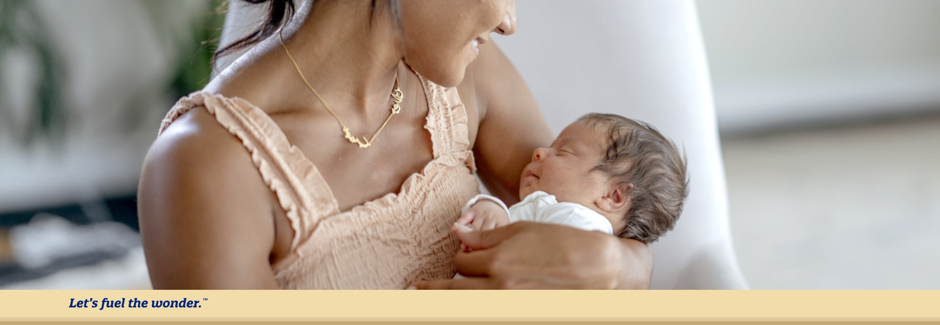 Sleeping baby being held in arms of smiling parent