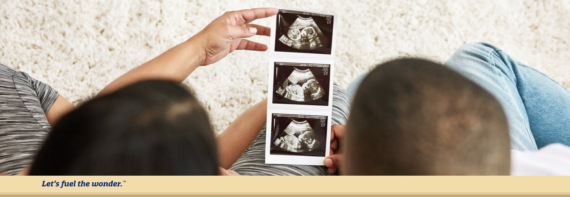 Partners sitting down together while holding and looking at ultrasound results