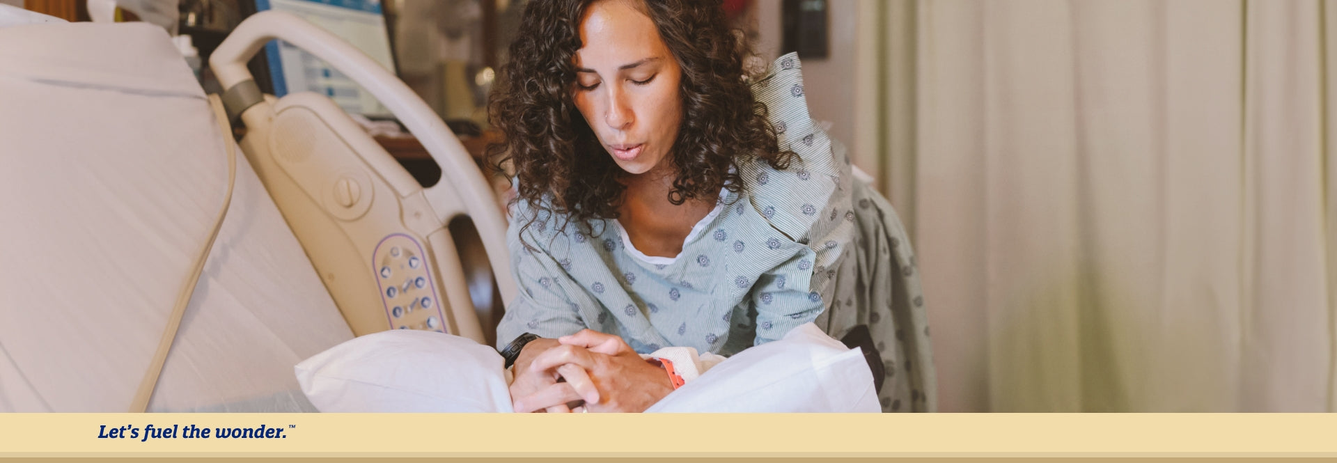 Woman with eyes closed leaning over on pillow on top of a hospital bed with hands together while performing a deep breathing exercise